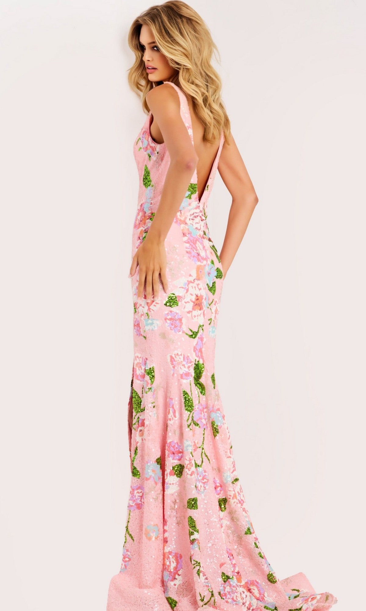 A woman models the Jovani 48636 long prom dress, featuring a fitted bodice and flared skirt in pink floral style, against a plain light background.